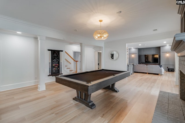 rec room with billiards, crown molding, a fireplace, and light hardwood / wood-style floors