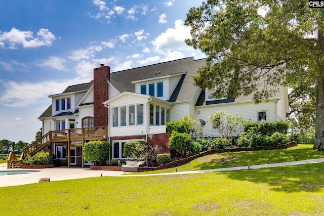 rear view of property featuring a pool side deck, a sunroom, a yard, and a patio area