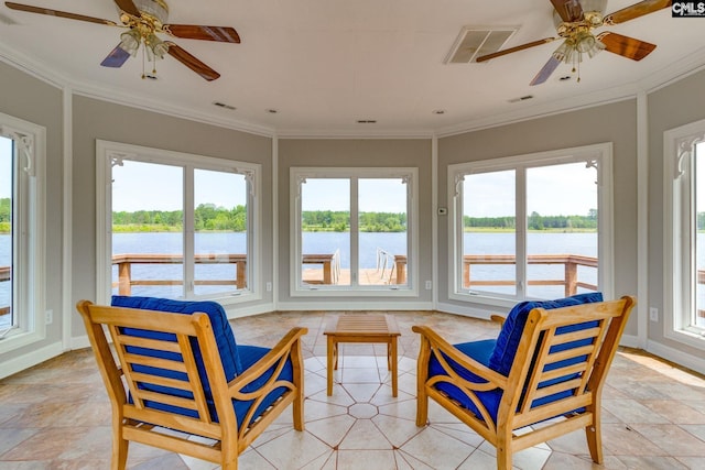 sunroom / solarium with ceiling fan and a water view