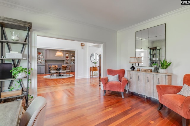 living area with hardwood / wood-style flooring and crown molding