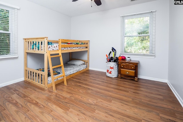 bedroom with a textured ceiling, wood-type flooring, and ceiling fan