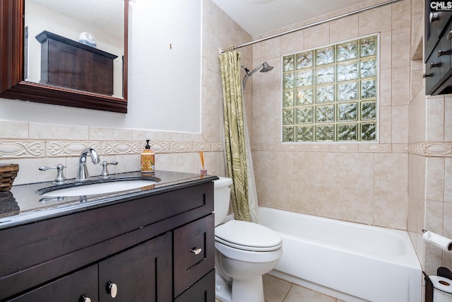 full bathroom with a textured ceiling, tile walls, shower / bath combo with shower curtain, toilet, and vanity