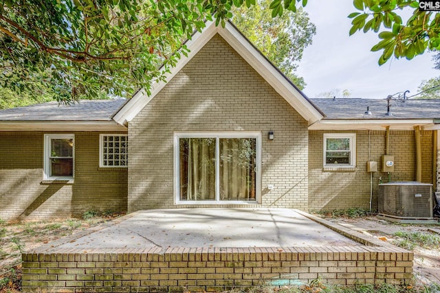 rear view of property with central air condition unit and a patio