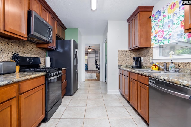 401 Nottingham Rd, Columbia, SC 29210 - kitchen featuring light tile patterned flooring, brown cabinets, tasteful backsplash, a sink, and stainless steel appliances