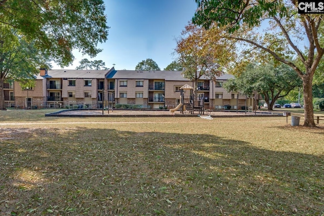 view of property's community featuring a playground and a lawn