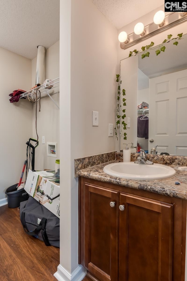 bathroom with vanity, a textured ceiling, and wood-type flooring