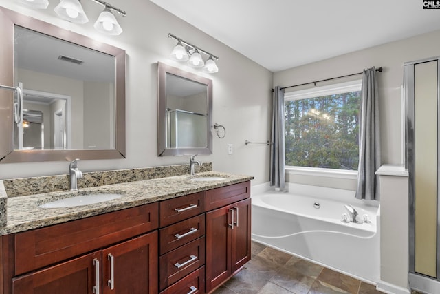 bathroom featuring vanity and independent shower and bath