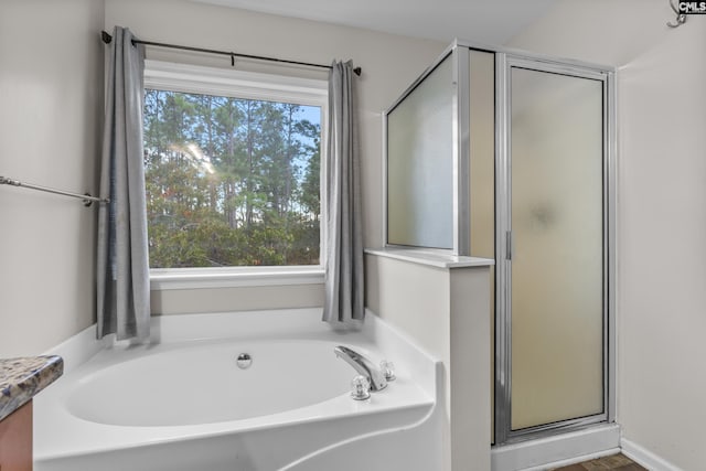 bathroom with a wealth of natural light and separate shower and tub