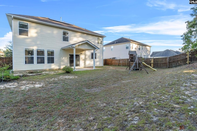 back of property with a patio, a playground, and a yard