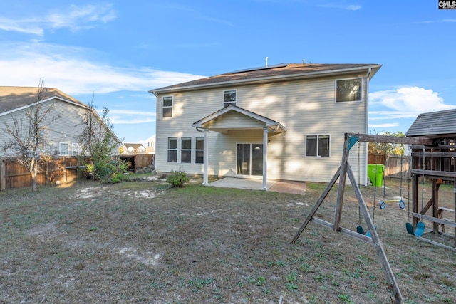 rear view of property with a patio area and a playground