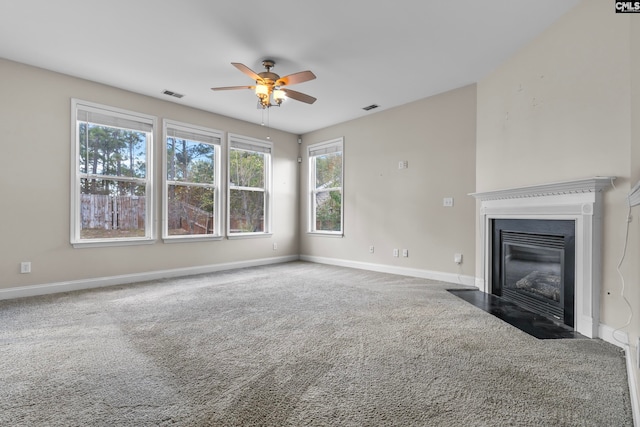 unfurnished living room with dark carpet and ceiling fan