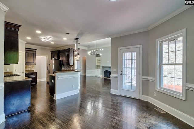 kitchen featuring dark brown cabinetry, dark wood-type flooring, plenty of natural light, and pendant lighting