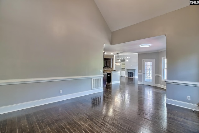 unfurnished living room with high vaulted ceiling and dark hardwood / wood-style flooring