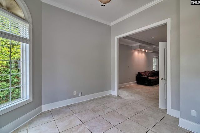 empty room featuring a healthy amount of sunlight, ornamental molding, and light tile patterned floors