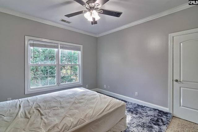 carpeted bedroom with ornamental molding and ceiling fan