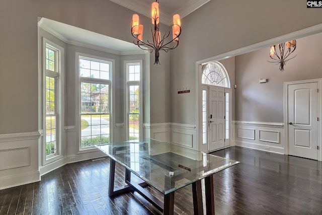 unfurnished dining area featuring ornamental molding, a wealth of natural light, and dark hardwood / wood-style flooring