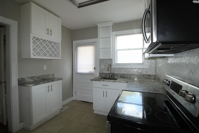 kitchen with a wealth of natural light, sink, white cabinetry, and stainless steel appliances