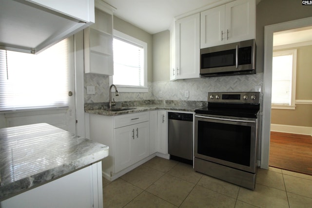 kitchen featuring sink, white cabinets, stainless steel appliances, and backsplash