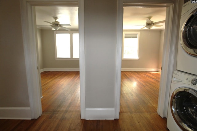 washroom featuring dark wood-type flooring, ceiling fan, and stacked washing maching and dryer