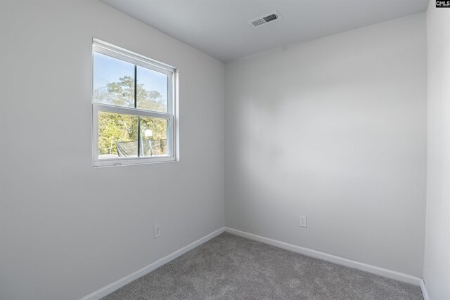 unfurnished room with carpet flooring, baseboards, and visible vents