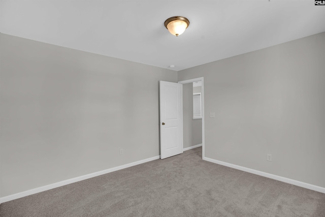 unfurnished room with carpet floors and baseboards