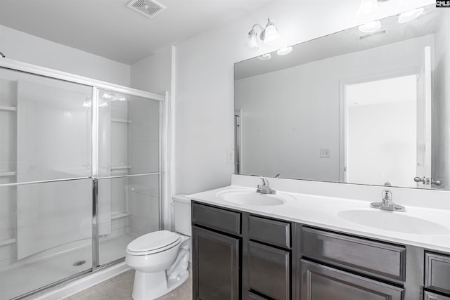 bathroom with toilet, vanity, and a shower with door