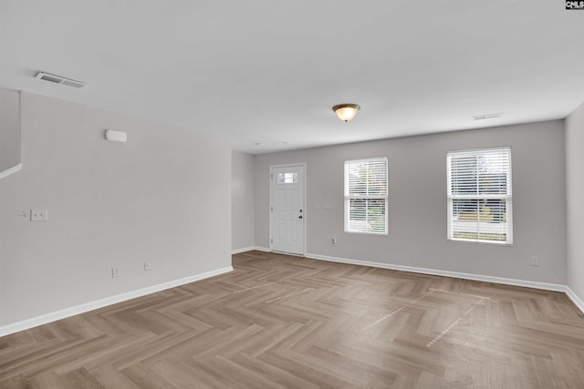 unfurnished room with baseboards and visible vents