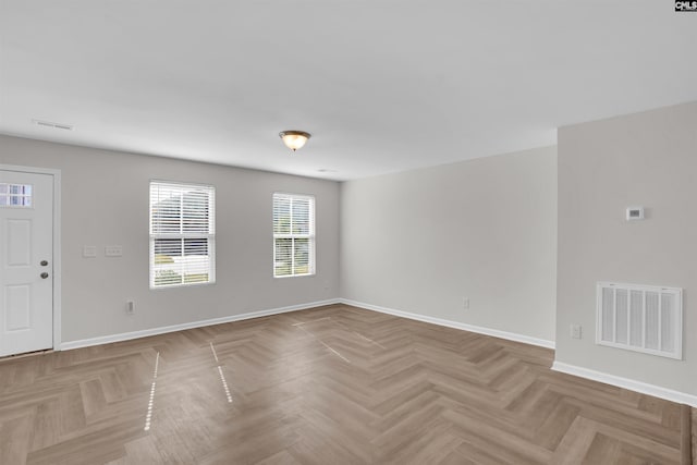 unfurnished room featuring baseboards and visible vents