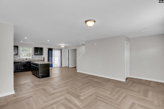 kitchen featuring baseboards, light countertops, and open floor plan