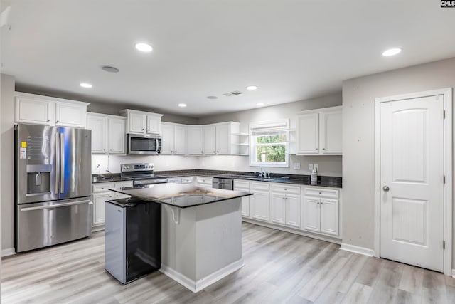 kitchen with a center island, white cabinetry, stainless steel appliances, and light hardwood / wood-style floors