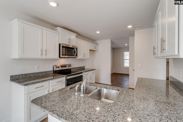 kitchen featuring white cabinetry, light stone counters, appliances with stainless steel finishes, and sink