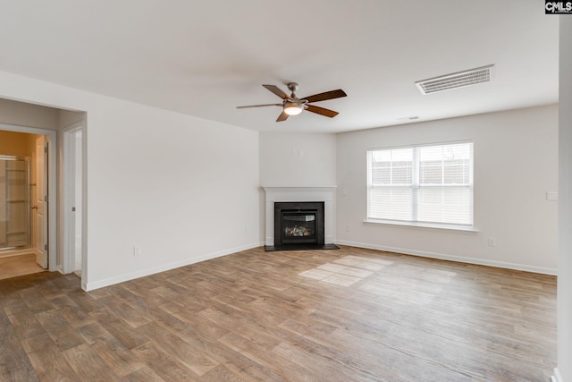 unfurnished living room with hardwood / wood-style flooring and ceiling fan