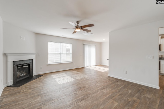 unfurnished living room featuring hardwood / wood-style floors and ceiling fan