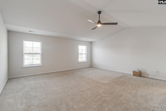 empty room featuring ceiling fan, lofted ceiling, and light colored carpet