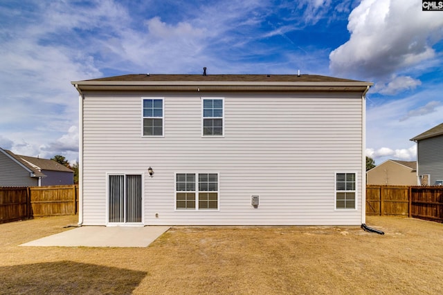 back of property with a yard and a patio area