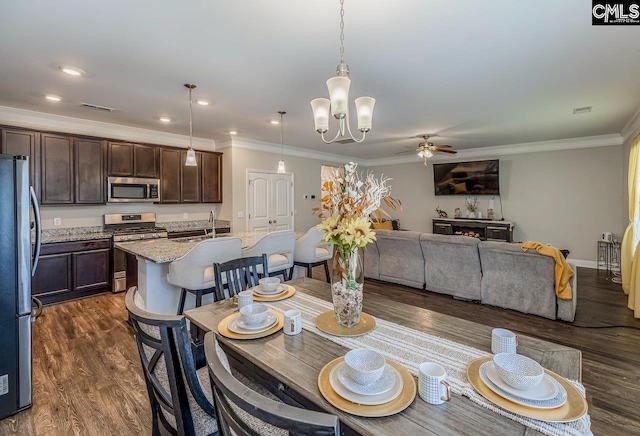 dining room featuring ornamental molding, dark hardwood / wood-style floors, sink, and ceiling fan with notable chandelier