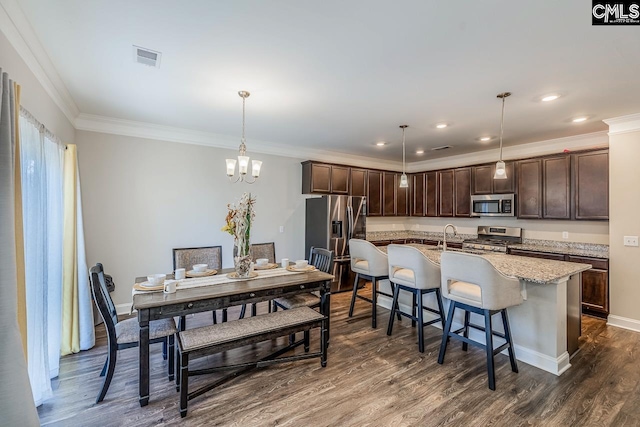 dining area featuring crown molding, a chandelier, dark wood-type flooring, and sink