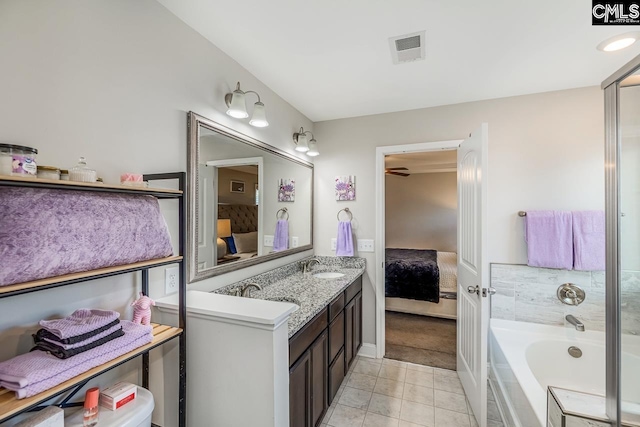 bathroom with vanity, tiled bath, and tile patterned flooring