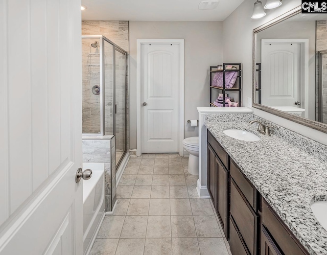 bathroom featuring vanity, a shower with shower door, toilet, and tile patterned flooring