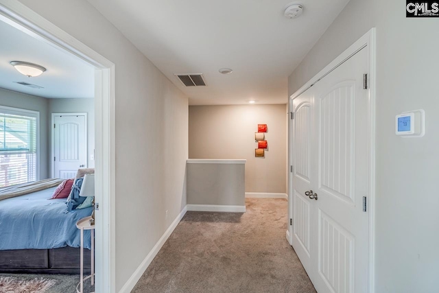 corridor featuring light colored carpet