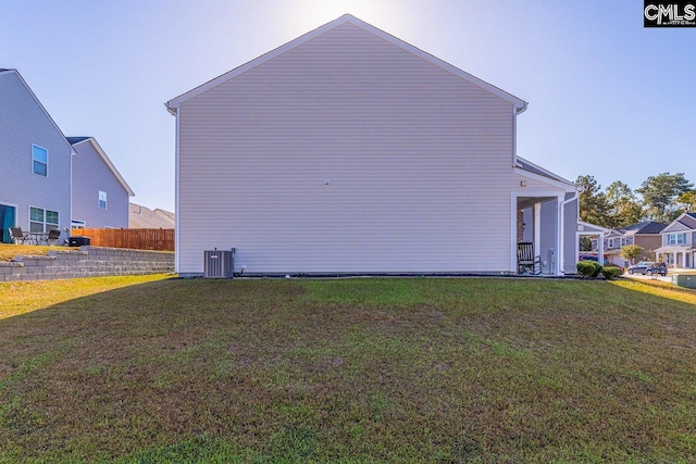 view of property exterior with a yard and central AC unit