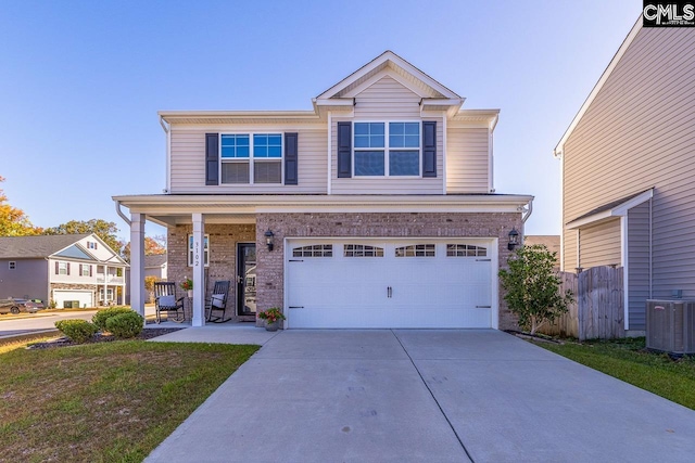 view of front of house featuring a garage, cooling unit, and a front lawn