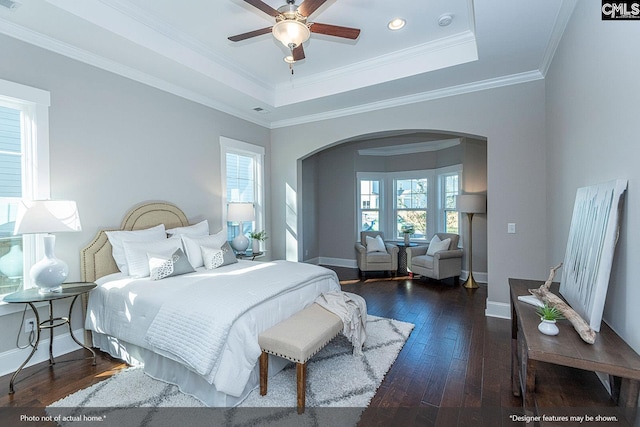 bedroom featuring ceiling fan, a raised ceiling, ornamental molding, and dark hardwood / wood-style floors