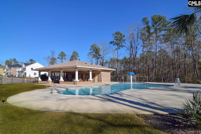 view of swimming pool with a patio, ceiling fan, pool water feature, and a lawn