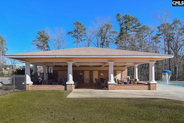 rear view of house with ceiling fan, pool water feature, a lawn, and a patio area