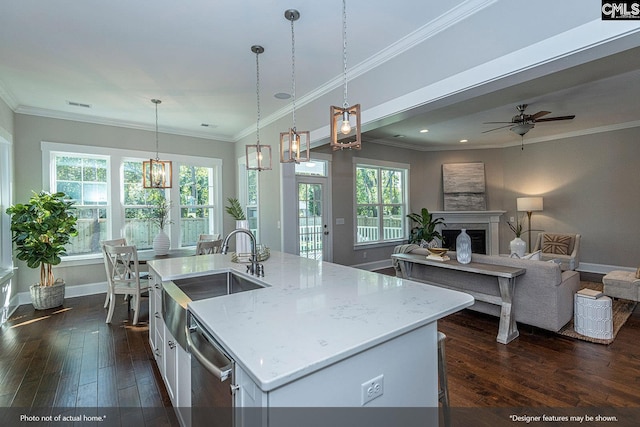 kitchen featuring dark hardwood / wood-style flooring, a wealth of natural light, hanging light fixtures, and an island with sink