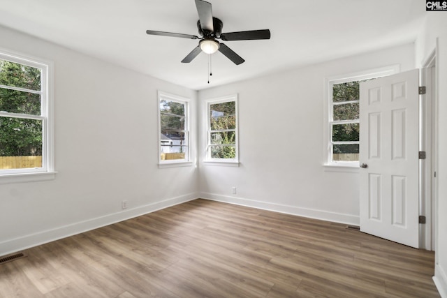 unfurnished room with ceiling fan, wood-type flooring, and a healthy amount of sunlight