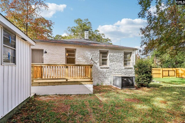 rear view of house with a yard and a wooden deck