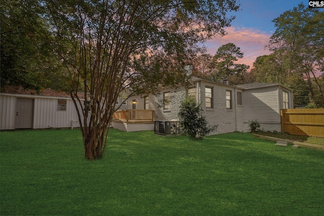 yard at dusk featuring a deck