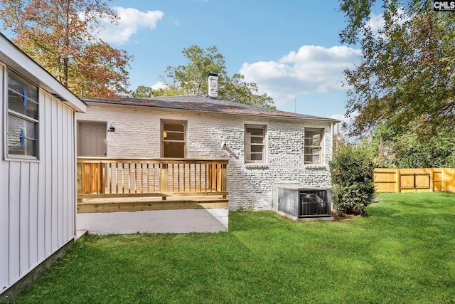 back of house featuring a wooden deck and a yard